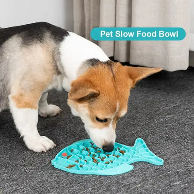 Dog eating from a blue silicone lick mat in fish shape designed as a slow food bowl to prevent gulping and choking