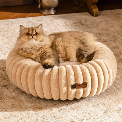 Light brown MEWOOFUN donut cat bed with fluffy round design and a relaxed cat lying inside on a rug